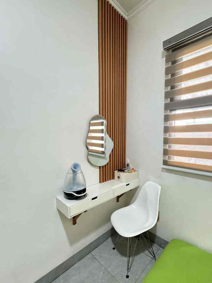 Small bedroom corner in white and wood tones featuring a simple wall-mounted shelf and chair with a minimalist vibe