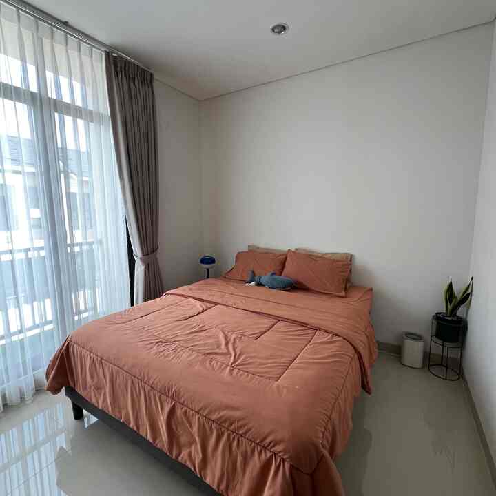 Beige-toned bedroom featuring brown bedding and a small plant, creating a cozy atmosphere