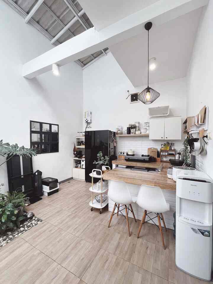 Modern kitchen space featuring white and wood tones, a dining table with chairs, and a pendant light creating a clean atmosphere