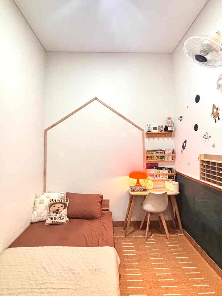 White and brown toned kids' room featuring a small bed, desk, and playful wall stickers creating a cozy atmosphere