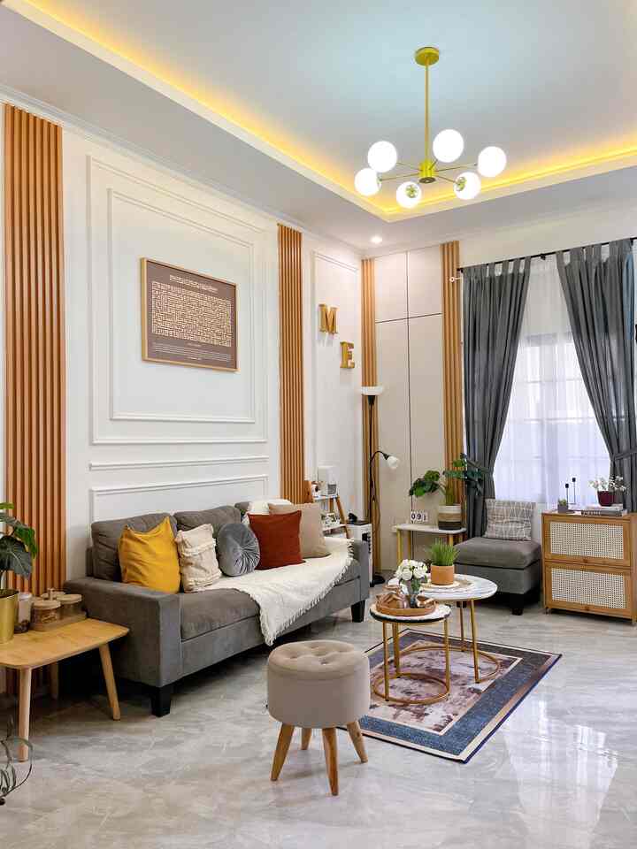 Cozy wood tone living room with gray sofa and wood accents, featuring natural plants and modern lighting elements