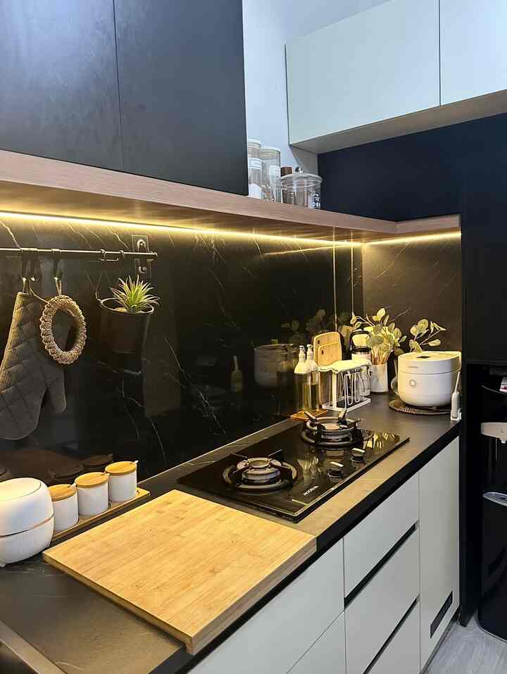 White and black toned kitchen space featuring a wooden cutting board and kitchen utensils with a clean, modern atmosphere
