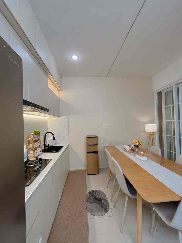 White and brown toned kitchen and dining area featuring natural wood furniture and minimal décor with warm ambiance