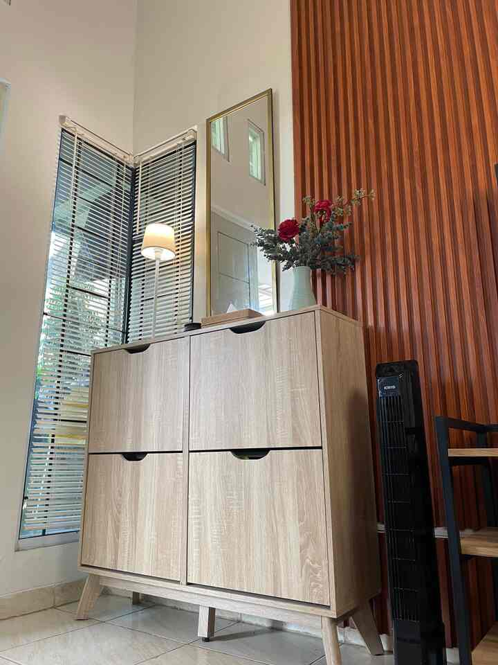 Wood tone entrance space featuring a shoe cabinet, mirror, and window blinds with a simple interior style