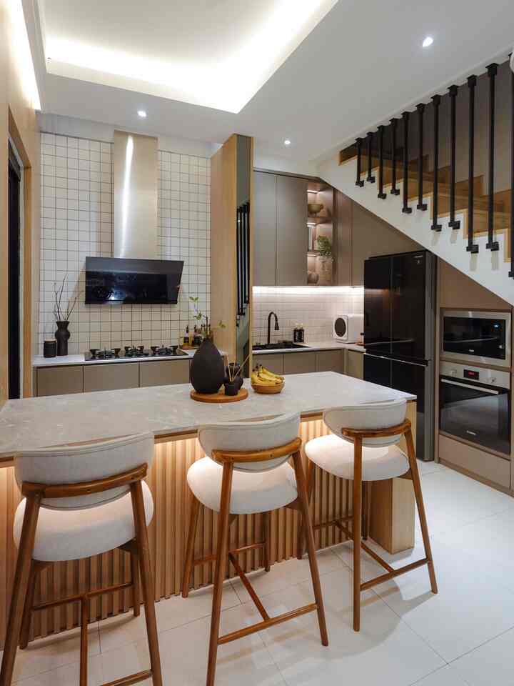 Modern kitchen in brown and white tones featuring a kitchen island with three chairs and a spacious atmosphere