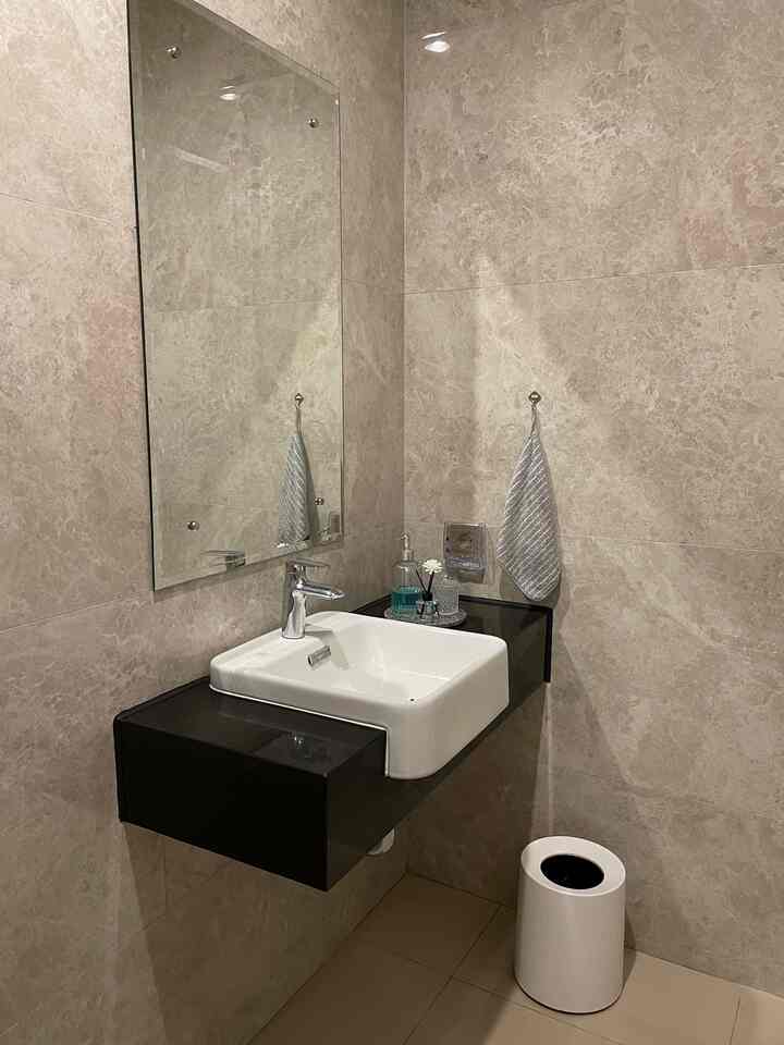 Kamar Mandi Mungil Rasa Hotel ✨

Kamar mandi lantai 1 di rumah ini punya ukuran yang cukup compact, hanya 1,2 x 2,5 meter. Tapi meskipun mungil, desain bawaan dari developernya sudah sangat proper dan fungsional. Dindingnya dilapisi granit full setinggi plafon dengan motif abu-abu elegan yang memberi kesan mewah. Lantainya juga menggunakan granit bertekstur kasar, jadi tetap aman meski dalam keadaan basah.

Yang paling bikin aku terkesan, semua sanitair dari wastafel, kran, toilet, hingga shower-nya sudah menggunakan Kohler — brand premium yang kualitas dan desainnya nggak perlu diragukan lagi 🙌🏻

Sebagai pecinta dekorasi kecil-kecilan, aku tambahkan sentuhan personal di sudut wastafel:

- Tray terrazzo 
 - Botol pump kaca untuk sabun tangan 
- Crystal tray untuk tempat perhiasan saat mencuci tangan
- Reed diffuser biar wangi kamar mandi selalu fresh 
Tak ketinggalan, aku juga pasang gantungan handuk kecil dan tempat sampah minimalis yang desainnya clean — bagian plastiknya tersembunyi, jadi tetap estetik dari luar.

Secara fungsi, kamar mandi ini udah sangat nyaman. Tapi ke depannya, aku kepikiran buat tambahin kabinet bawah wastafel sebagai storage untuk perlengkapan bersih-bersih dan refill sabun. Tunggu update makeover-nya yaa!

#newhome #firsthouse #americanclassic #modern #classic #timeless #bathroom #luxury #powderroom #elegant #classic
#clean
