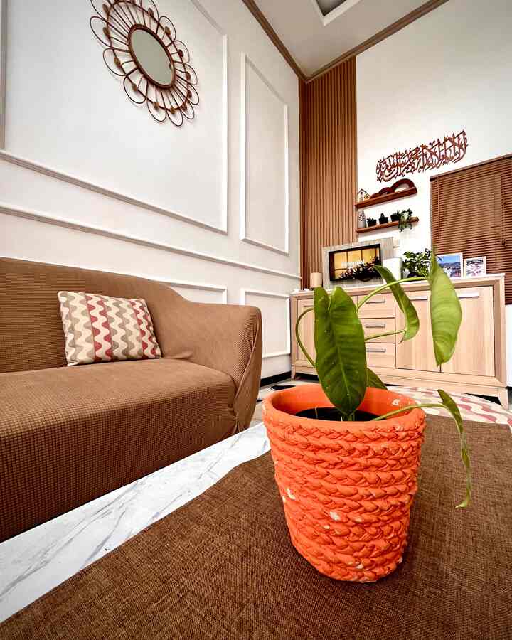 Brown and natural color living room featuring a brown sofa and an orange plant pot on a table with cozy atmosphere