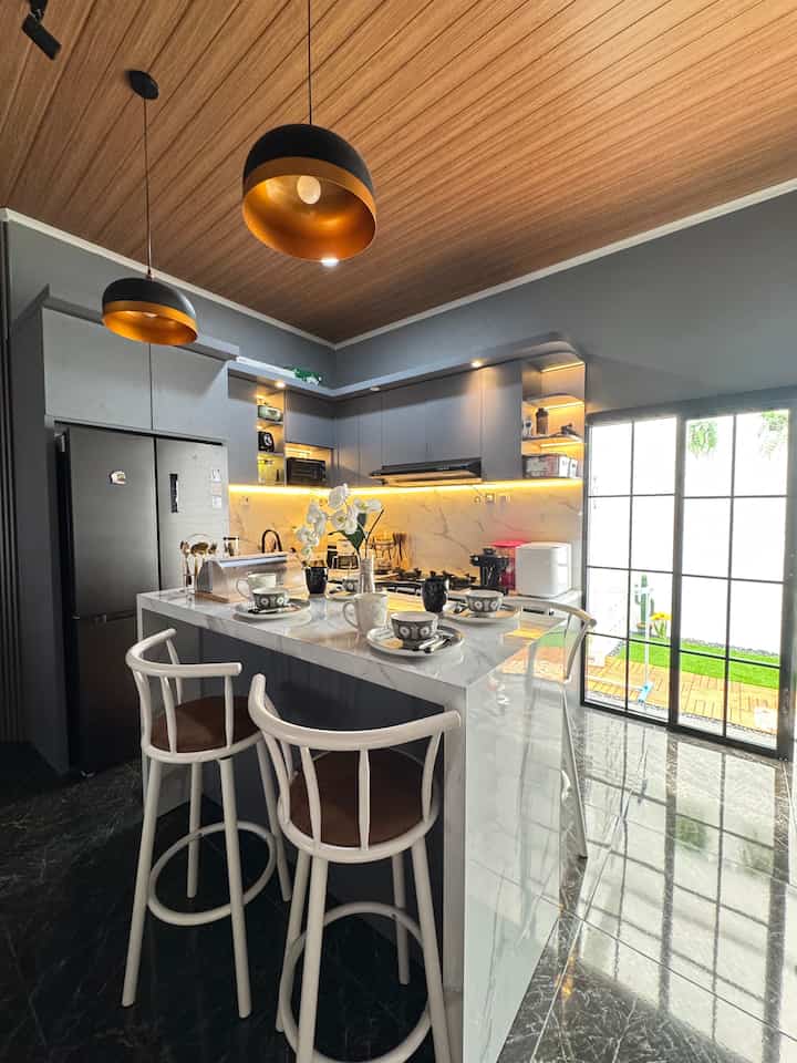 ✨Dapur bukan hanya sekedar tempat memasak, ini adalah ruang cinta, cita rasa dan cerita. Sedikit perubahan di dapur bisa berdampak besar loh tetangga online, yuk sharing perubahan apa yg ada di dapur kalian?!💕

Karena rumah kami temanya open space jadi antara ruang tamu,ruang keluarga dan area dapur jadi satu tanpa sekat. Selain efisiensi ruang, dapur jadi satu dengan area ruang keluarga ini menurut kami menambah keakraban dengan anggota keluarga karena saat menyiapkan makanan di dapur semua anggota keluarga bisa langsung melihat dan menemani jadi suasana memasak lebih asik. Namun jangan lupa untuk menambahkan exhause sebagai penghisap asap saat memasak agar seisi rumah gak bau masakan.
Dapur kami tidak begitu besar hanya berukuran 9m2 dengan bentuk letter L, dan table island sebagai meja makan. Kitchen set kami request banyak kabinet agar barang-barang tersimpan rapi di dalam.


#KitchenSet #KitchenSetMinimalis #PlavonPVC #WarnaCatRumah #MejaGranit #PintuAluminium #CatRumah #MyDreamKitchen #KitchenRenovation #KitchenStyling

