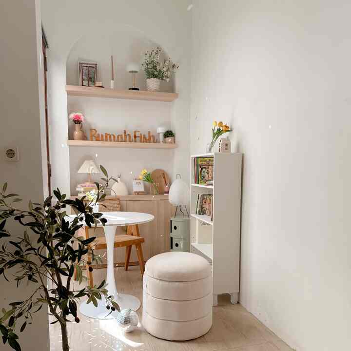 Small dining room in white and beige tones featuring natural wood furniture and plants with a simple, natural atmosphere