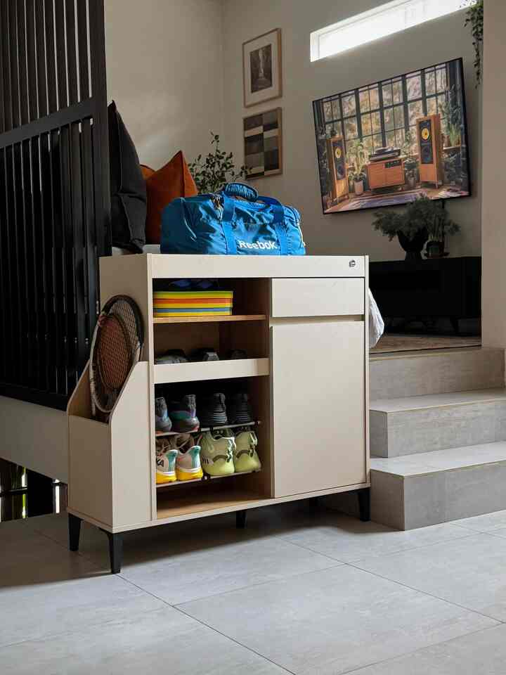 Beige storage cabinet with shoes in a bright, monotone living room entrance space