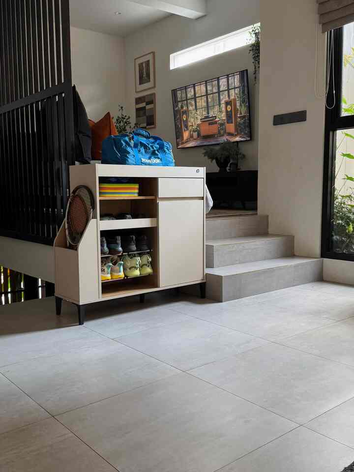 Beige and gray toned entrance area featuring a shoe cabinet and storage unit, creating a clean and practical interior