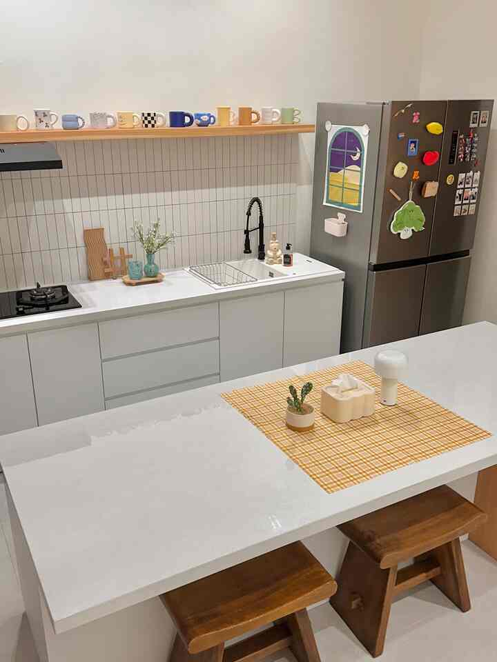 I like cute things.
So when I started decorating the kitchen, that’s exactly the direction I went.
Aku pilih perintilan lucu buat di dapur, kaya handuk tangan bentuk brokoli, magnet plushie yang lucu-lucu buat di kulkas, kain dekor kecil yang gemes, sama vas kaca warna-warni yang bikin suasana jadi cerah. Gak ada tema khusus sih sebenernya, I just added whatever made me smile.

Terus di rak terbuka atas backsplash, aku taruh koleksi mug-mug aku. Selain emang koleksi, ya sekalian jadi dekor juga. And a small way to show a bit of me in the space.

Not sure if it’s everyone’s cup of tea, but it definitely makes cooking and cleaning feel a bit more fun😄💕🌼

#backsplashdapur #hplputih #stoolkayu #mydreamkitchen #kitchenrenovation #kitchenstyling #dalkomspace