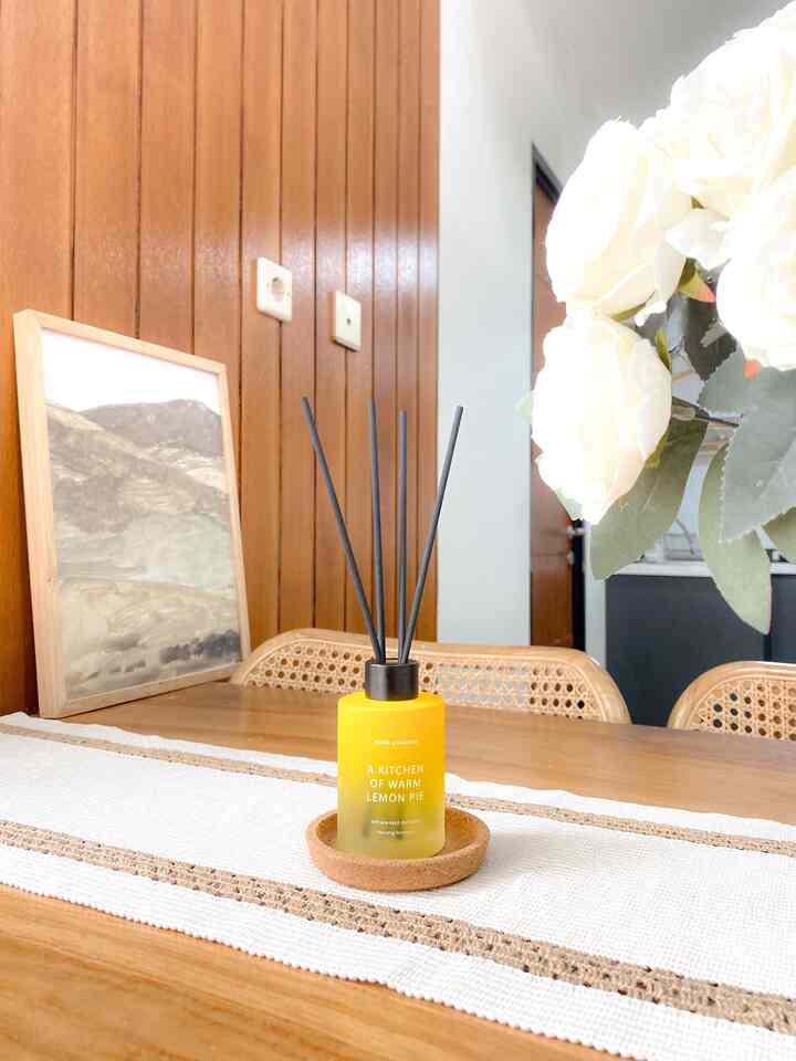 Natural brown-toned kitchen space featuring a wooden dining table with a yellow diffuser, creating a cozy atmosphere