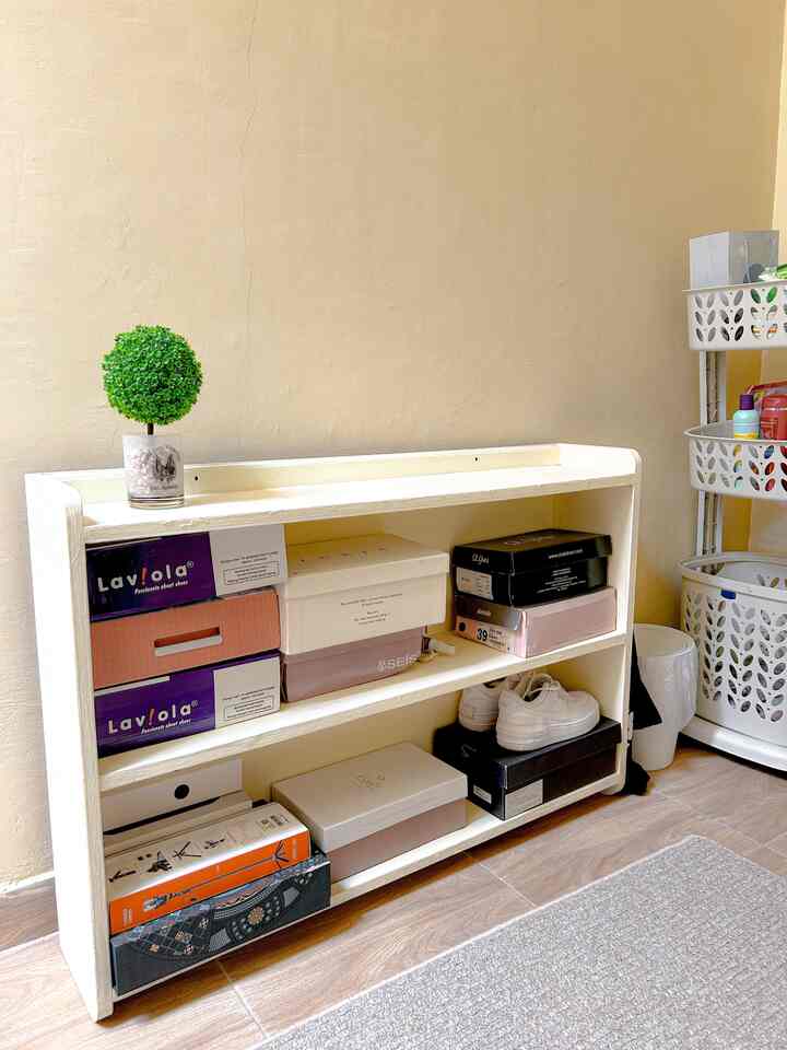 Beige-toned wall and cream shoe cabinet with various shoe boxes arranged in a neat storage area