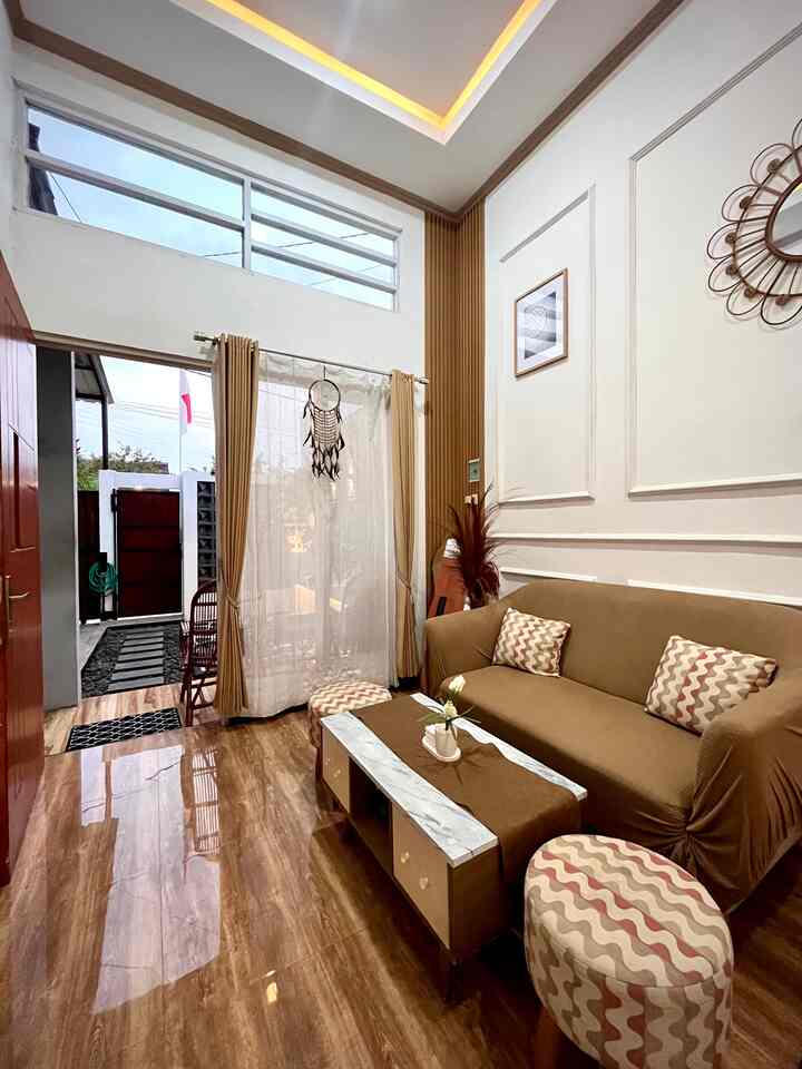 Bright cozy living room with brown wood-tone floor and beige sofa