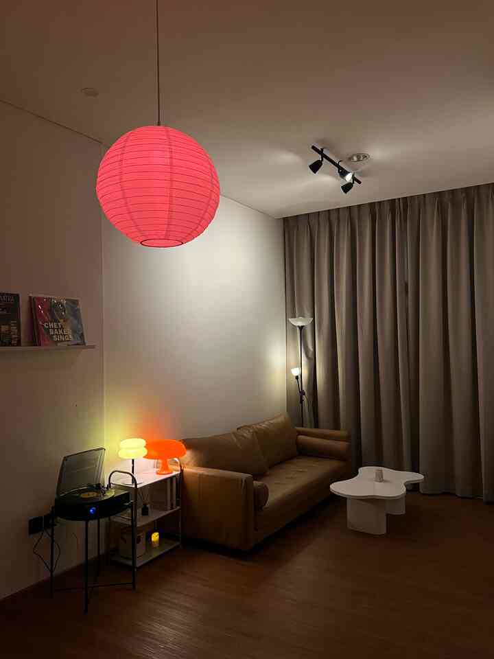 Night vibe di Hygge House saat semua lampu dinyalain dan suasana berubah jadi lebih hangat dan tenang.

Lampu gantung merah ini jadi fokus utama ruangan, ngasih kesan hangat yang beda. Di pojokan, turntable muter lagu-lagu lama, temenin malam sambil duduk santai di sofa coklat favorit. Nggak banyak barang, tapi cukup. Ruangan ini memang sengaja dibuat simpel, biar tiap detailnya bisa dinikmati.

Kadang hal-hal kecil kayak gini yang bikin betah di rumah.

#RumahOpenSpace #RumahTanpaSekat #NightVibe #InteriorRumah #DekorasiMinimalis #LivingRoomVibes #EstetikaRuang #CahayaMalam #ModernLiving #HomeStyle #OpenSpaceLiving #RumahNyaman #InteriorHangat #DesainRumah #ScandiModern #SimplicityAtHome #HomeMood #SuasanaMalam #MinimalisEstetik #LampuEstetik #MejaUnik #VinylCorner #CintaRumah #CintaMalamHari
