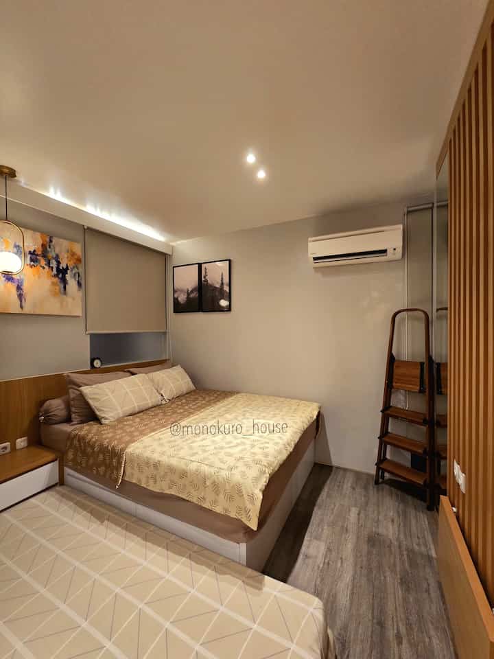 Soft brown and beige toned bedroom featuring two beds and blinds with a cozy atmosphere