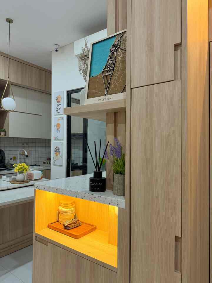 Natural-toned kitchen and storage area featuring illuminated cabinetry and lavender plant, creating a clean atmosphere