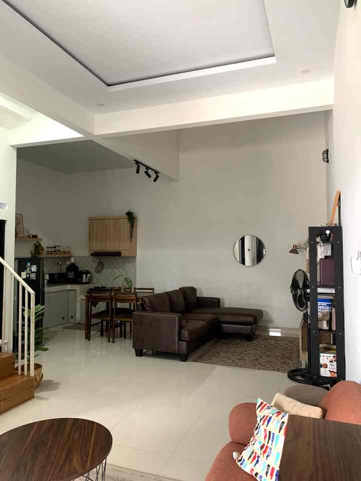 Natural brown-toned open-plan living and dining room featuring a sectional sofa and wooden dining table in a modern setting