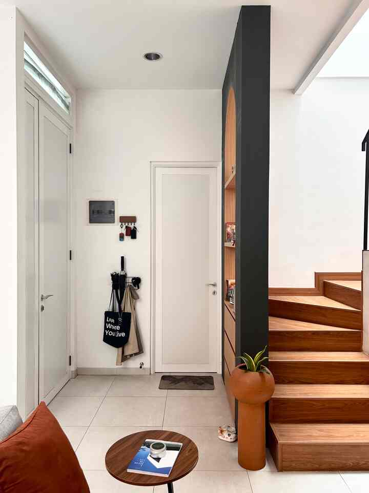 Area Foyer Rumah Introvert 👋🏻
Sebetulnya desain sederhana saja, tadinya ide dari genkan di desain rumah Jepang, namun kami tidak ingin membuat beda leveling di dalam rumah karena alasan keamanan dan kemudahan mobilitas. Di balik pintu terdapat gantungan kunci mobil/motor dan rak payung, tas, dan jaket. 
Karena posisi pintu utama buka dari samping kami mebuat partisi agar tidak langsung terlihat area tangga. Partisi ini dibuat fungsional untuk rak pajangan di bagian atas dan laci penyimpanan di bagian bawahnya. Bentuk partisi juga dibuat melengkung agar lebih menarik serta warna dan material yang senada color pallete interior kami.

#FoyerArea #InspirasiDesain #DesainFoyer #GantunganKunci #RakPayung #RakPajangan