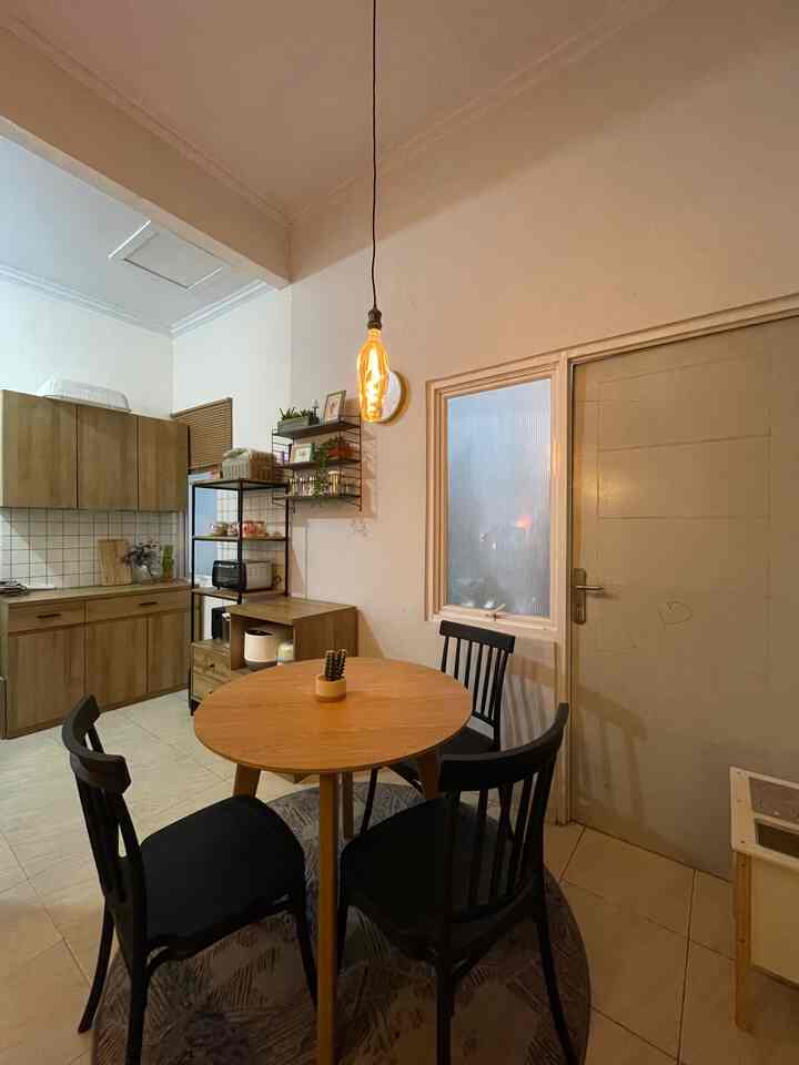 Wood tone and black kitchen featuring a round dining table and chairs with a warm atmosphere