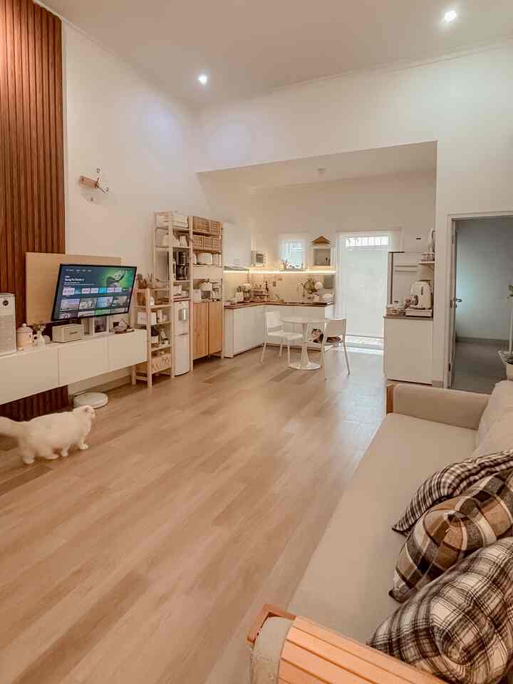 Natural color and white toned living room and kitchen-dining area, featuring an open-plan layout and wood tone furniture with a warm, spacious atmosphere
