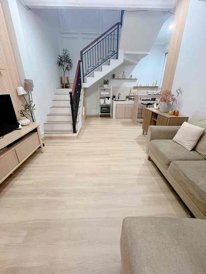 Natural-toned wood floor living and kitchen area featuring sofa and open, clean spaciousness