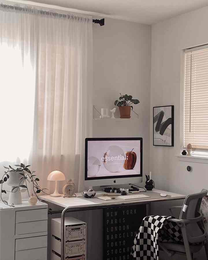 White-toned compact home office featuring iMac, desk, plants, and table lamp in a clean workspace