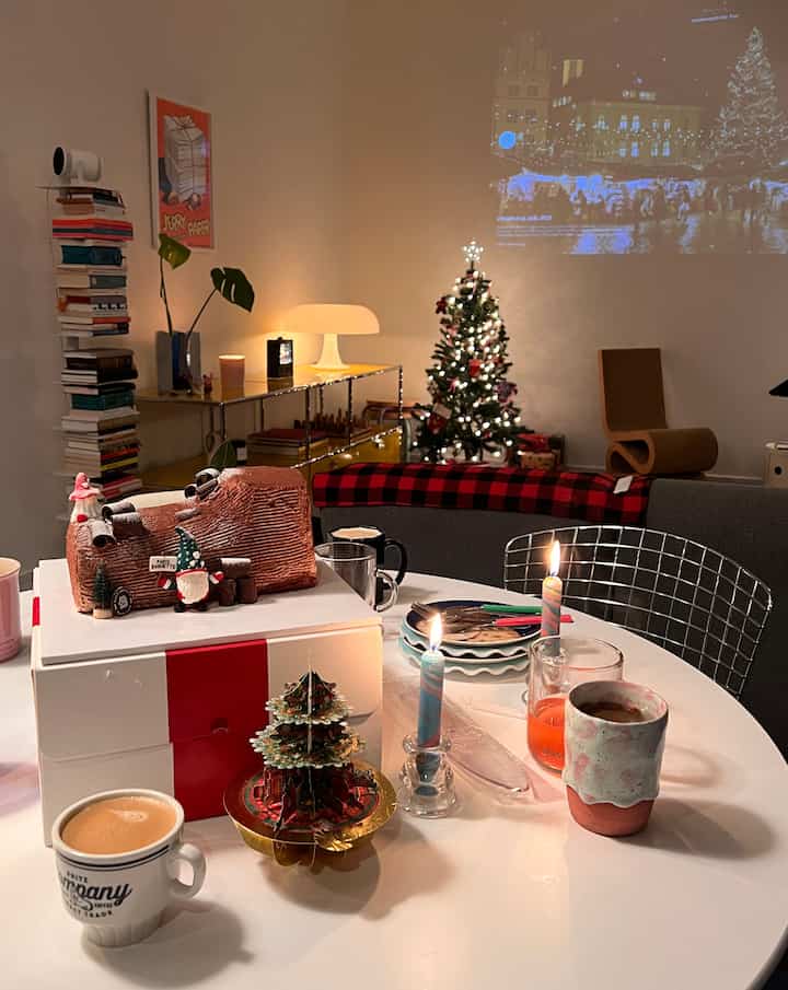 White-walled dining room featuring a decorated Christmas tree and festive tableware, creating a cozy holiday atmosphere