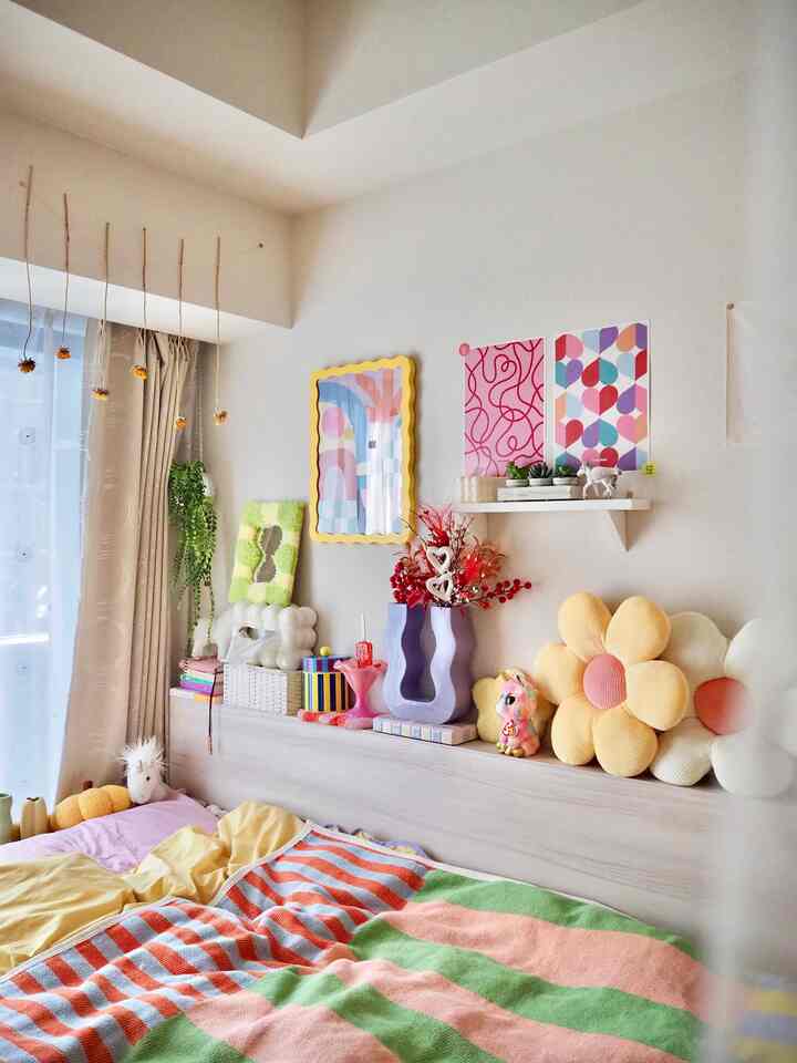 優しいベージュとイエローの色調の寝室、花の形のクッションと壁のアートが調和した雰囲気のあるインテリア