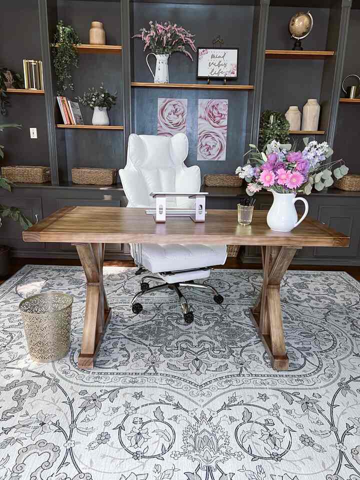 Gray walled home office featuring a wood-tone desk and a white office chair centrally placed for a clean work setup