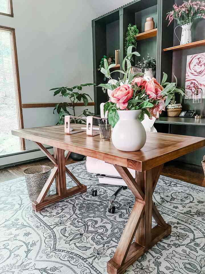 Bright natural brown tone home office featuring a large wooden desk and floral vase in a modern farmhouse style interior
