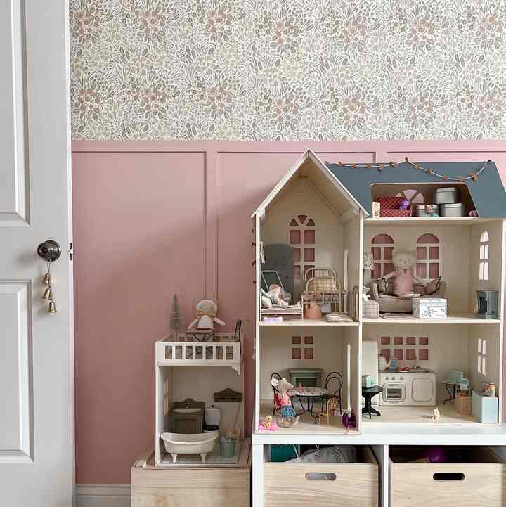 Pink and beige toned kids' room wall with a charming dollhouse creating a cozy atmosphere