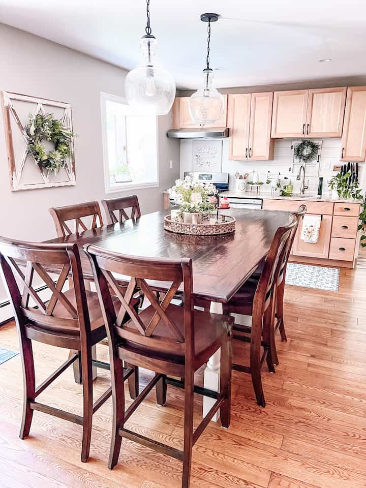 Wood tone and white kitchen-dining room featuring a large dining table and pendant lights with a warm atmosphere