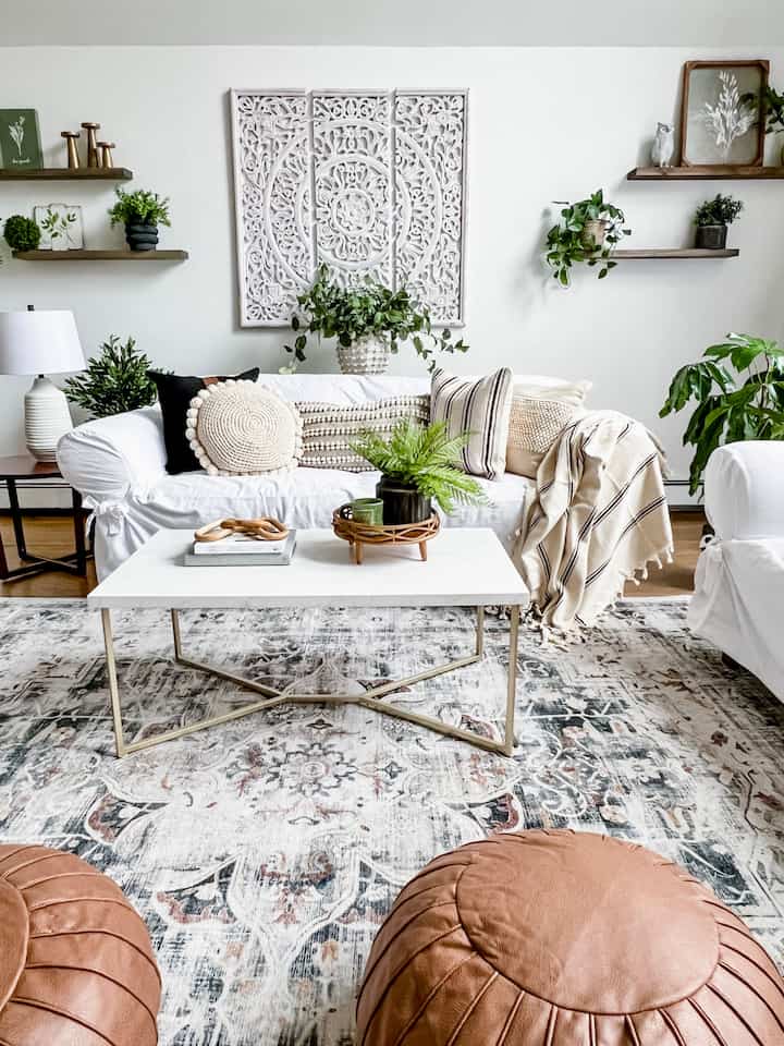 White and green-themed Bohemian living room featuring sofas, coffee table, and decorative plants with a cozy and relaxed atmosphere