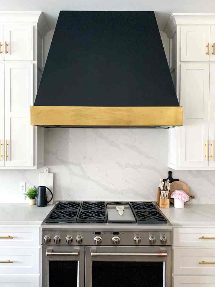 Dapur hitam putih modern yang dilengkapi dengan tudung pernyataan berwarna hitam dan emas.
#blackandwhitekitchen #venthood #statementhood #kitchendesign #slabbacksplash #whitequartz