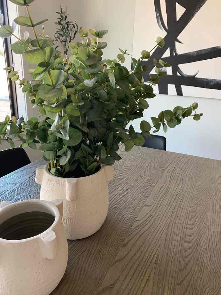 Centerpieces kept simple with a set of matching planters and faux eucalyptus. #diningroom #centerpiece #moderndiningroom