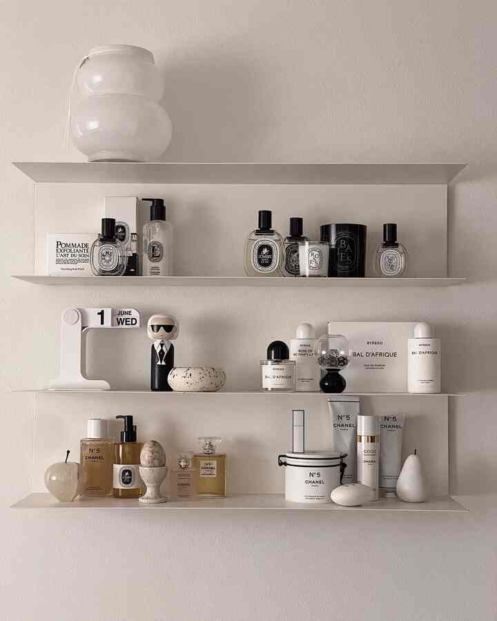 Simple interior space with white-tone shelves neatly displaying candles, perfumes, and diffusers