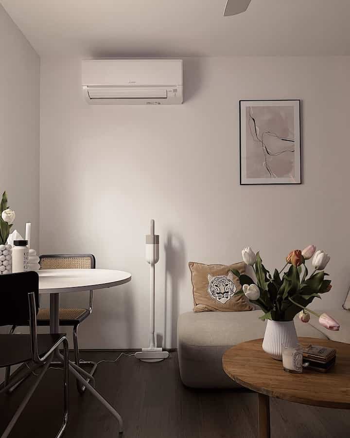 a small, cozy living room on the second floor.

#livingroom #livingroominterior #livingroomdecor #vase #flower #posterframe #poster #roundtable #cushion #cordlessvacuumcleaner #candle 