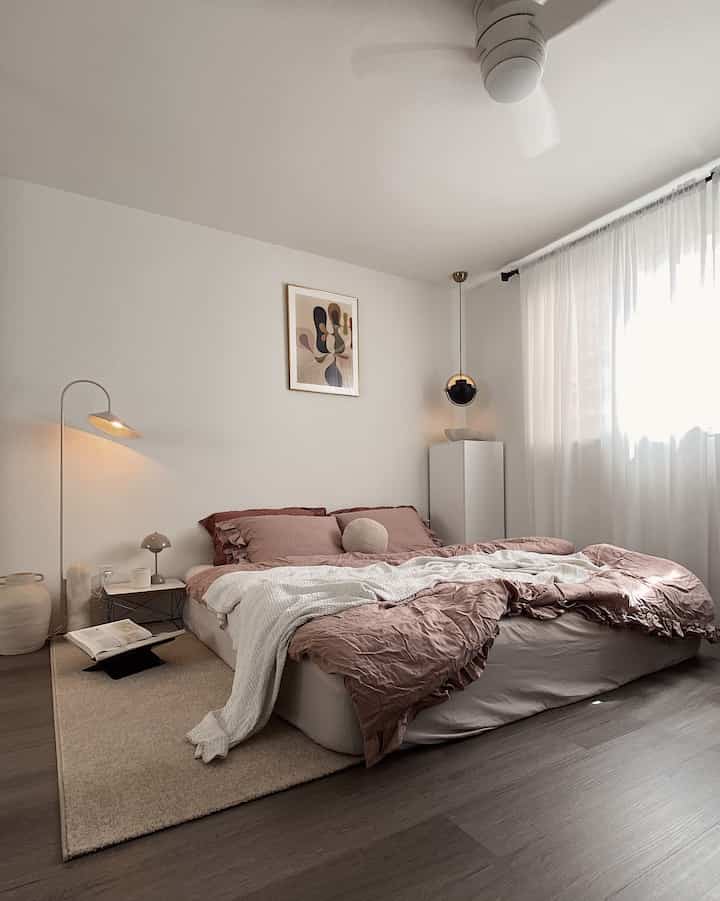 Natural-toned simple and minimal bedroom featuring brown bedding and soft white curtains