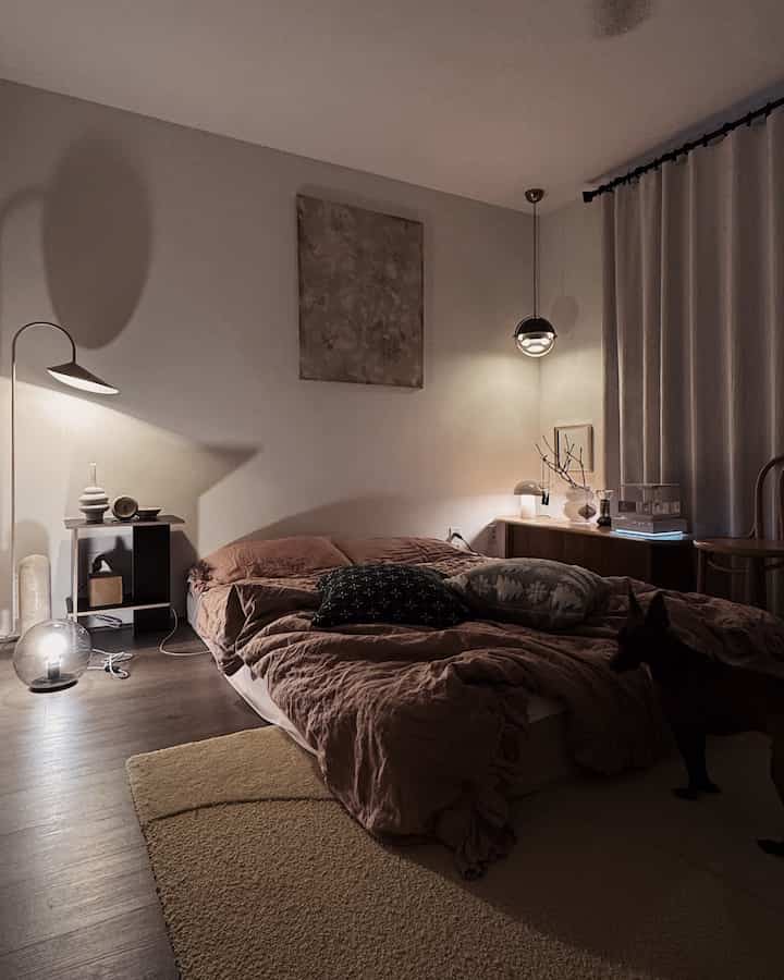 Brown and gray toned bedroom featuring modern natural furniture and a pet dog, creating a warm atmosphere