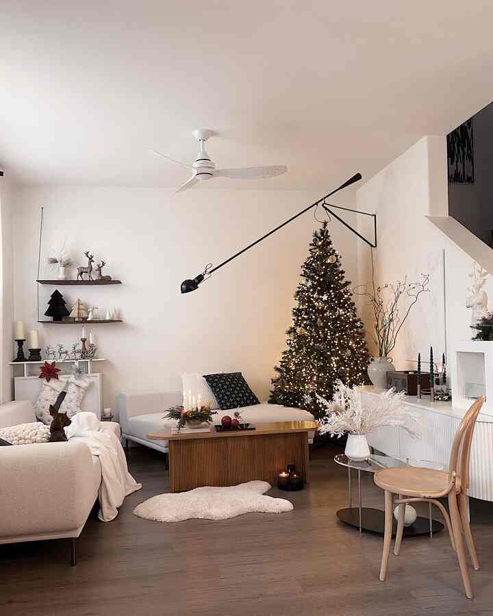 Neutral-toned living room featuring a decorated Christmas tree and natural wood furniture with a cozy atmosphere