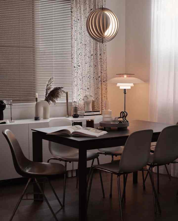 A brown wood-toned and white dining room featuring a modern dining table and chairs creating a cozy atmosphere