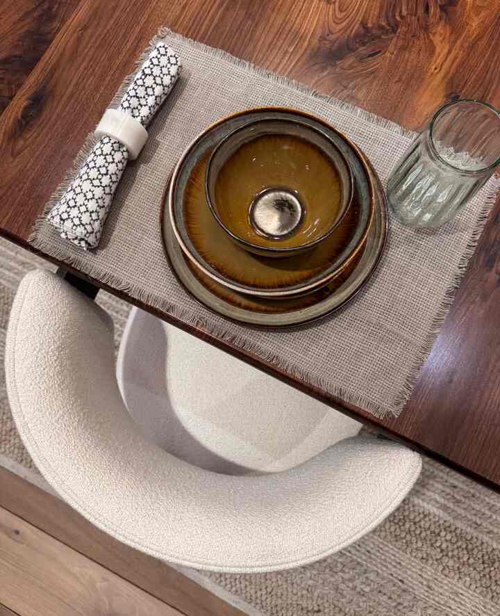 Beige-toned dining table featuring brown bowls and a clear glass in a stylish dinnerware setup