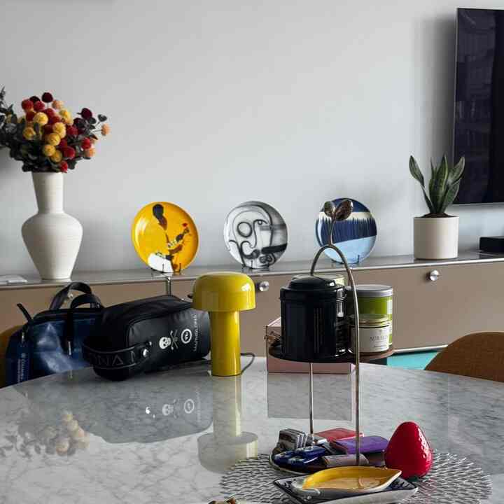 White and yellow toned living room featuring vase, plant, and decorative plates with a cozy atmosphere