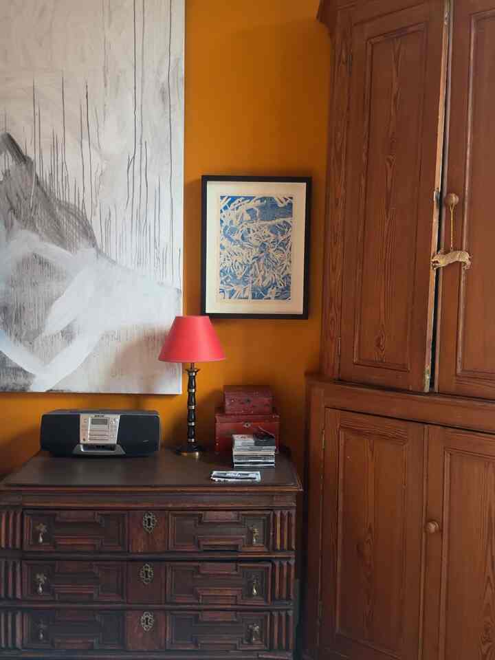 Art Deco bedroom with orange walls featuring brown wooden furniture and a red table lamp