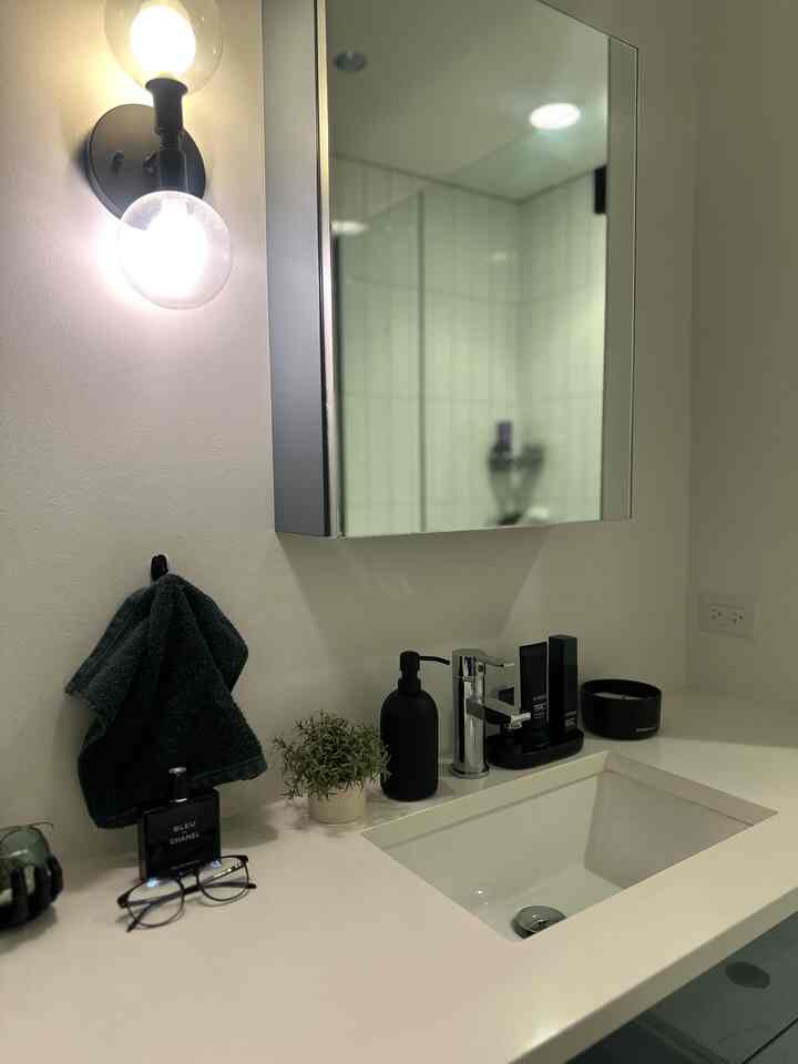 White and black toned bathroom featuring a simple sink and mirror with minimal decorative items, creating a clean space