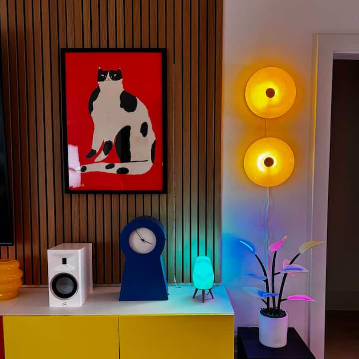 Yellow and blue themed entrance featuring cat wall art, a clock, and table lamp creating a cozy vibe