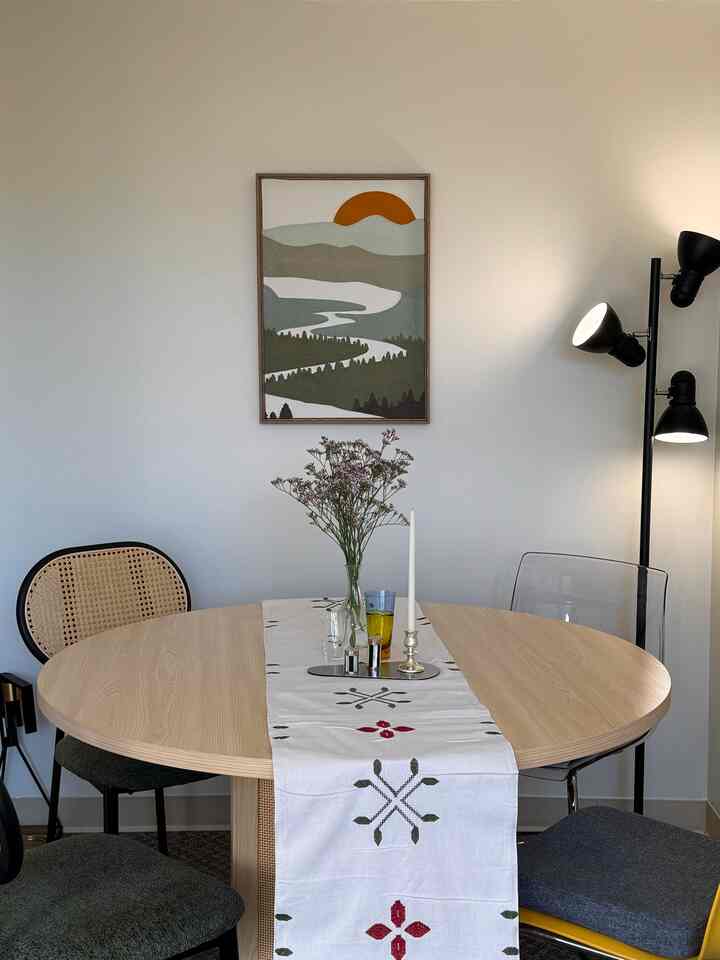 Natural color and black tones dining room featuring a round dining table with assorted chairs in a natural modern style