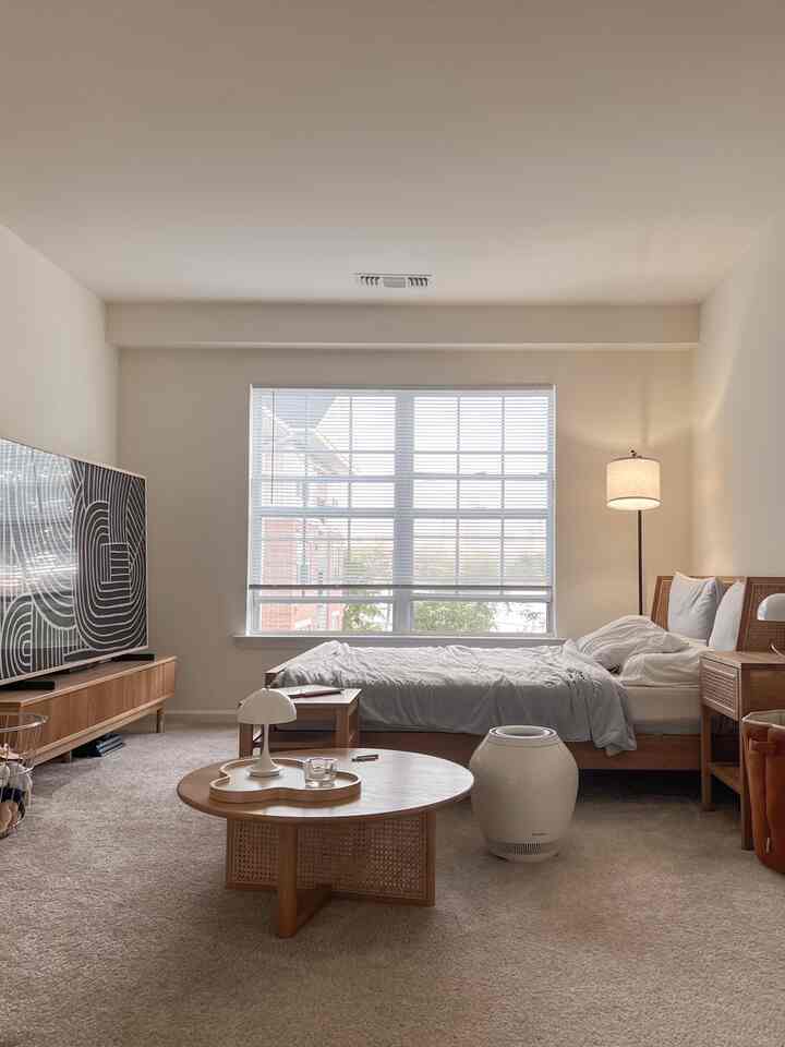Beige-toned bedroom featuring wooden furniture and a large window with a natural, modern atmosphere
